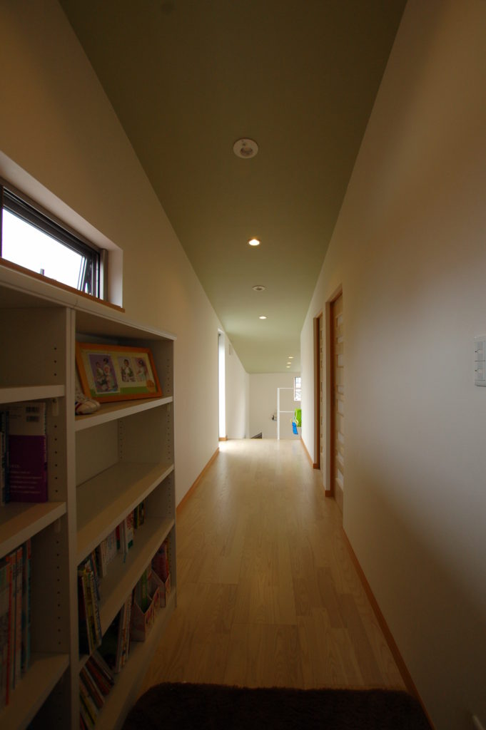 家の中に光を取り込む中二階リビングを持つモスグリーンのフォルムが特徴の家