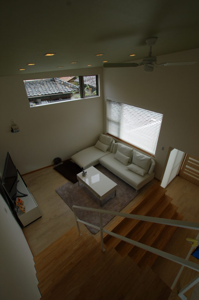 家の中に光を取り込む中二階リビングを持つモスグリーンのフォルムが特徴の家